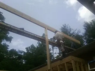 Carpenter setting a ridge beam over a new addition frame — Ice Dam Removal by Roofing Brothers in South Dartmouth