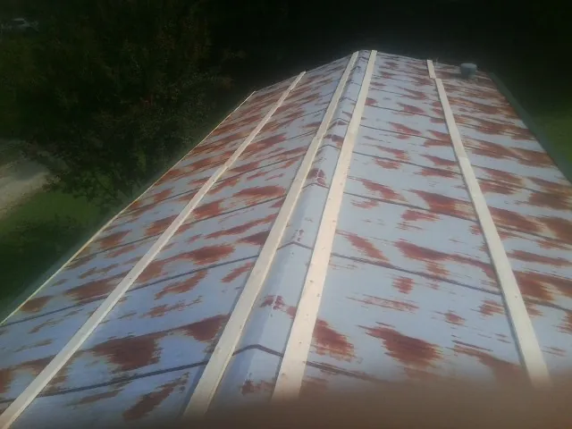 Rusted metal roof panels with new wood purlins before replacement — Storm Damage Roof Repair in South Dartmouth by Roofing Brothers