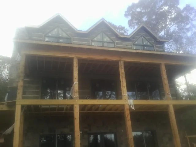 Dormers and porch framing on a large log home under construction — Roof Coating work by our crew in South Dartmouth