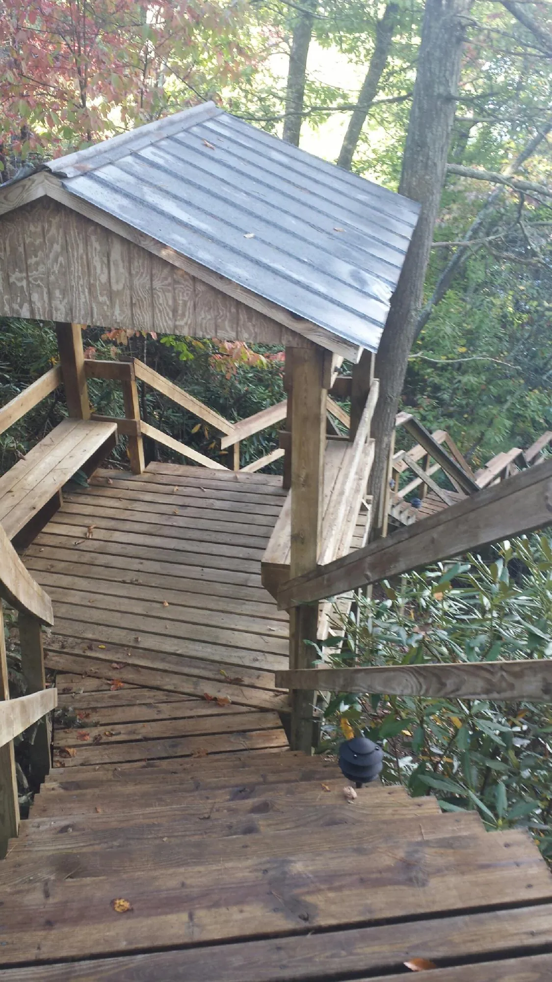 Metal roofed shelter over wooden steps on a wooded walkway — Skylight Repair & Installation work by our crew in South Dartmouth
