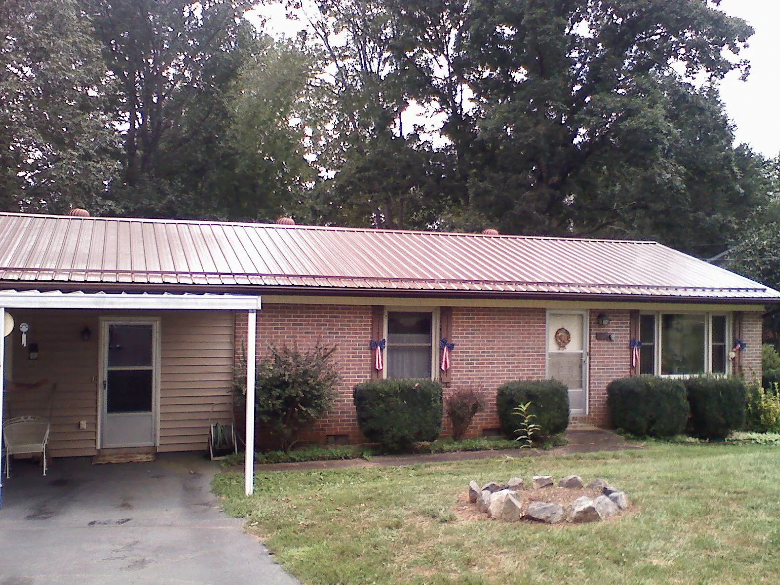 Bronze metal roof and carport on a brick ranch home — Roof Repair work by our crew in South Dartmouth